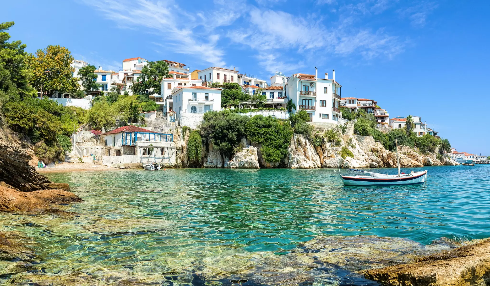 Boats float on the water of a sparkling bay 
