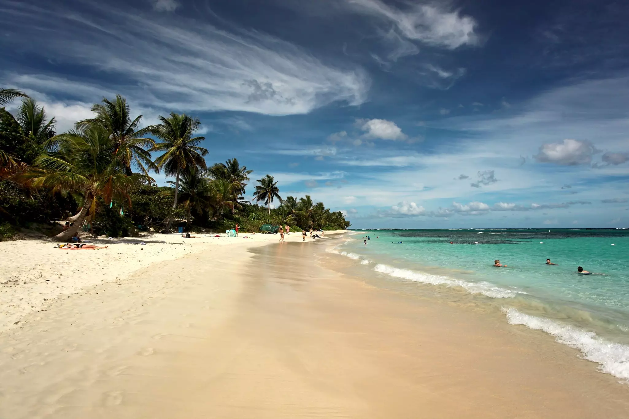 Culebra, Puerto Rico - 01 04 2017: Flamenco Beach with bright Sand, turquoise Water and blue Sky with some Clouds - People on the Beach and in the Water in Background