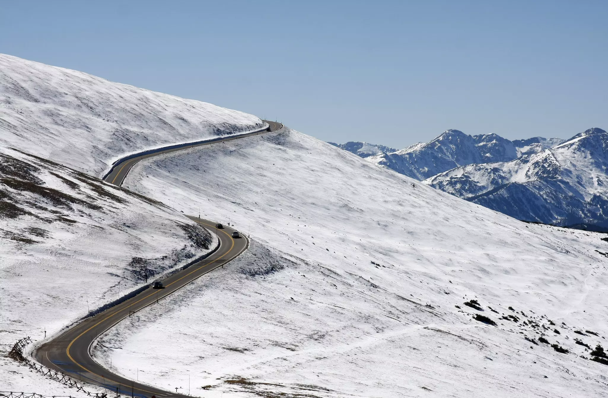 A winding road snakes up a snow-covered mountain.