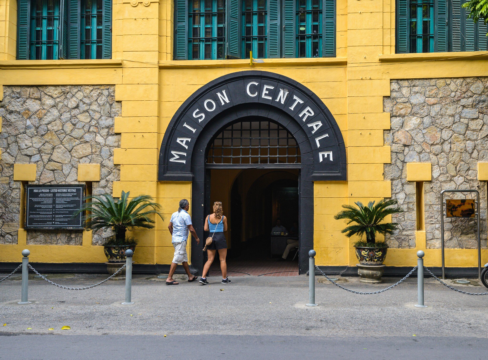 Two people enter the Hoa Lo Prison in Hanoi, Vietnam.
