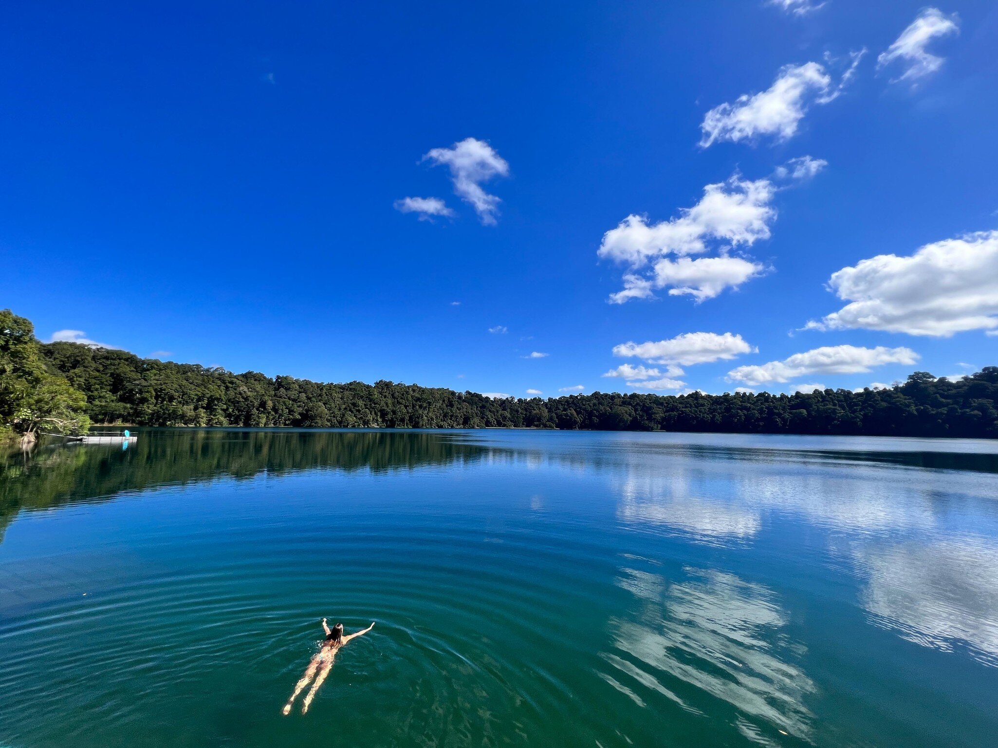 Aerial landscape view of Australian woman swim in Lake Eacham, a popular lake of volcanic origin on the Atherton Tableland in tropical far north of Queensland Australia.