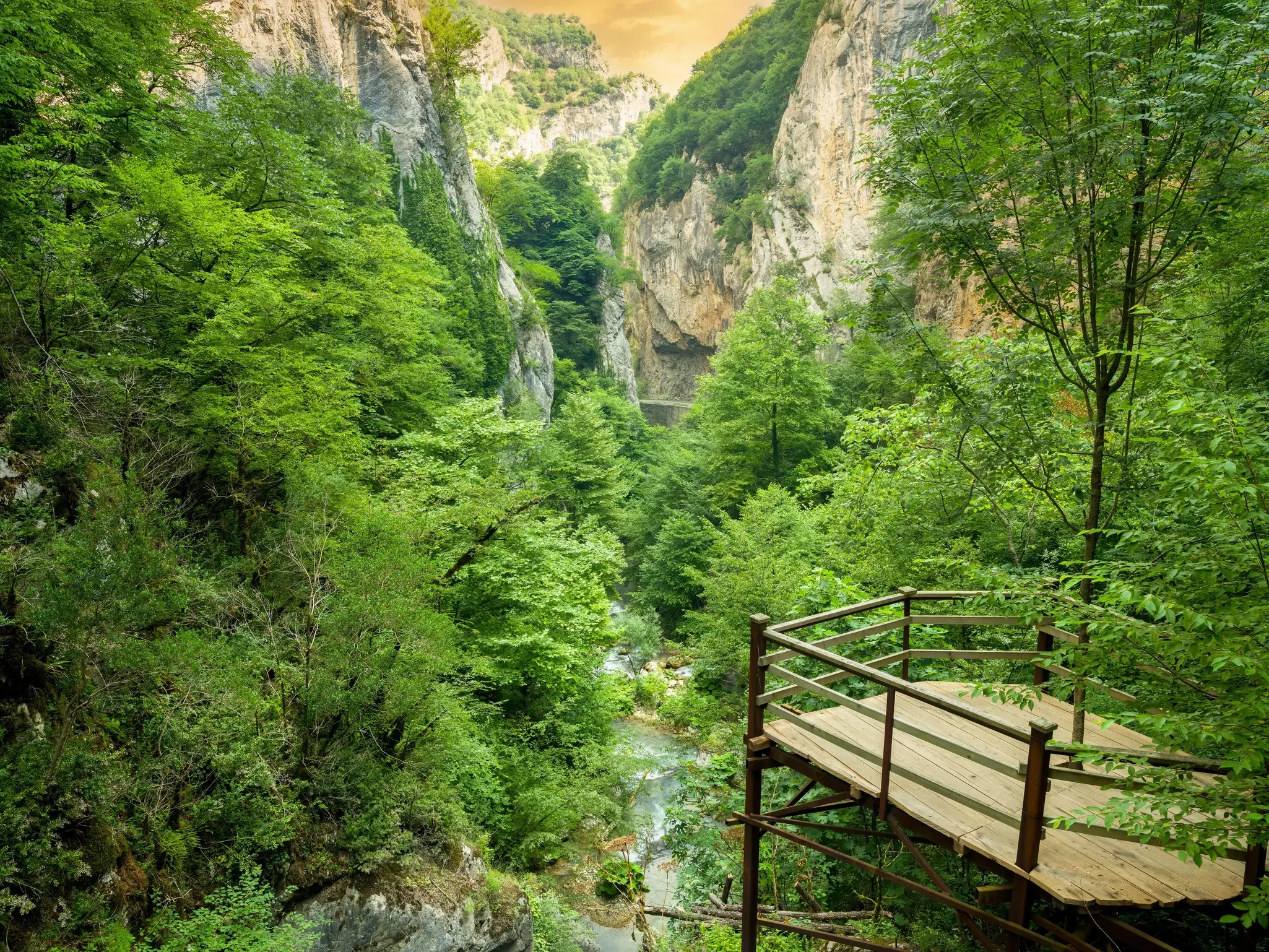 A platform juts out over a lush scenic river canyon.