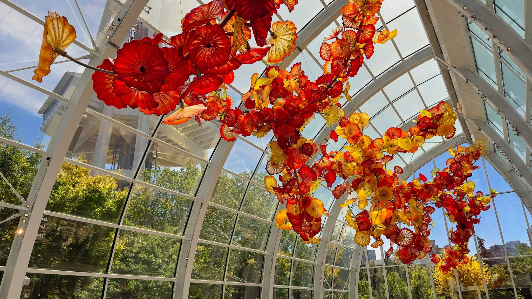 Tangled strings of blown glass flowers hang from the top of the Glasshouse at Chihuly Gardens and Glass