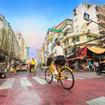 A traveler riding on a bicycle to see the city life in the morning in the Chinatown of Bangkok or Yaowarat Road