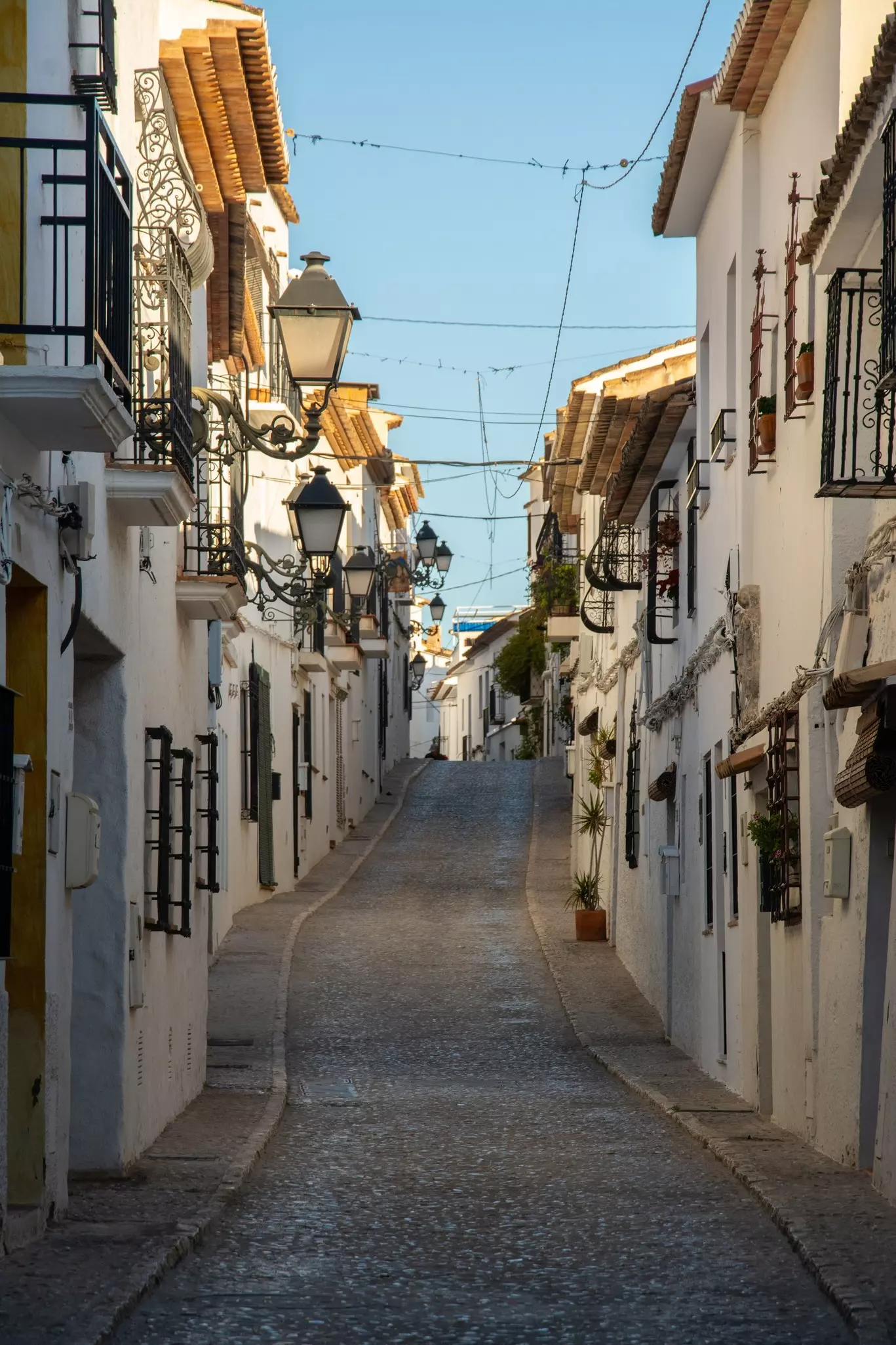 View of the narrow cobblestone street with whitewashed houses in an old town part of Altea resort town on Costa Blansa, Spain