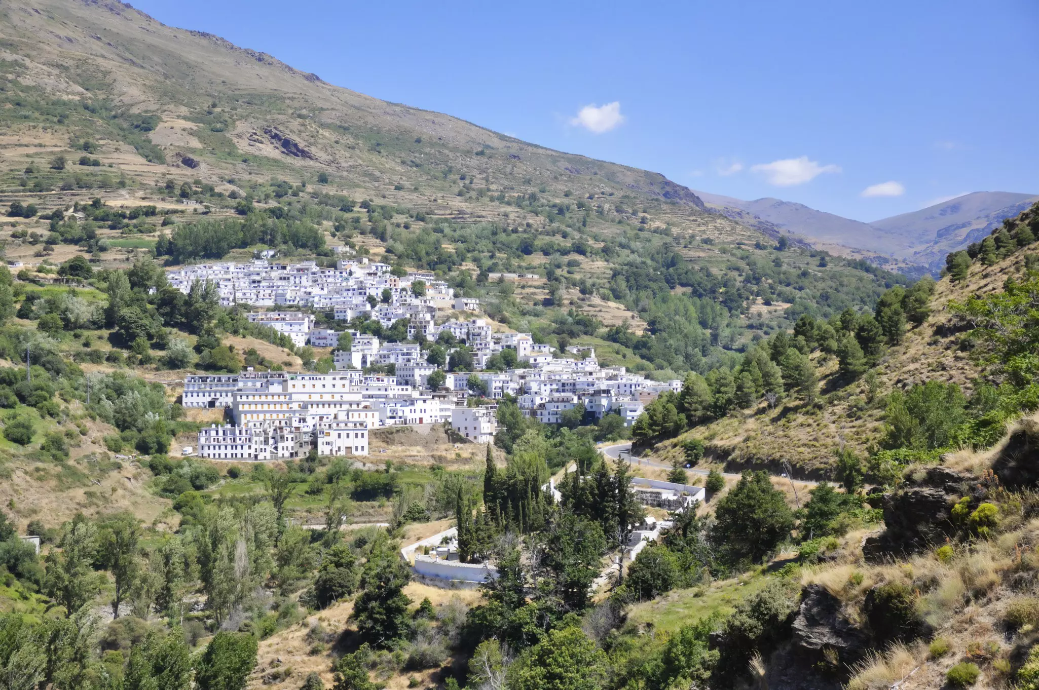 A village of white houses tucked into a mountain valley