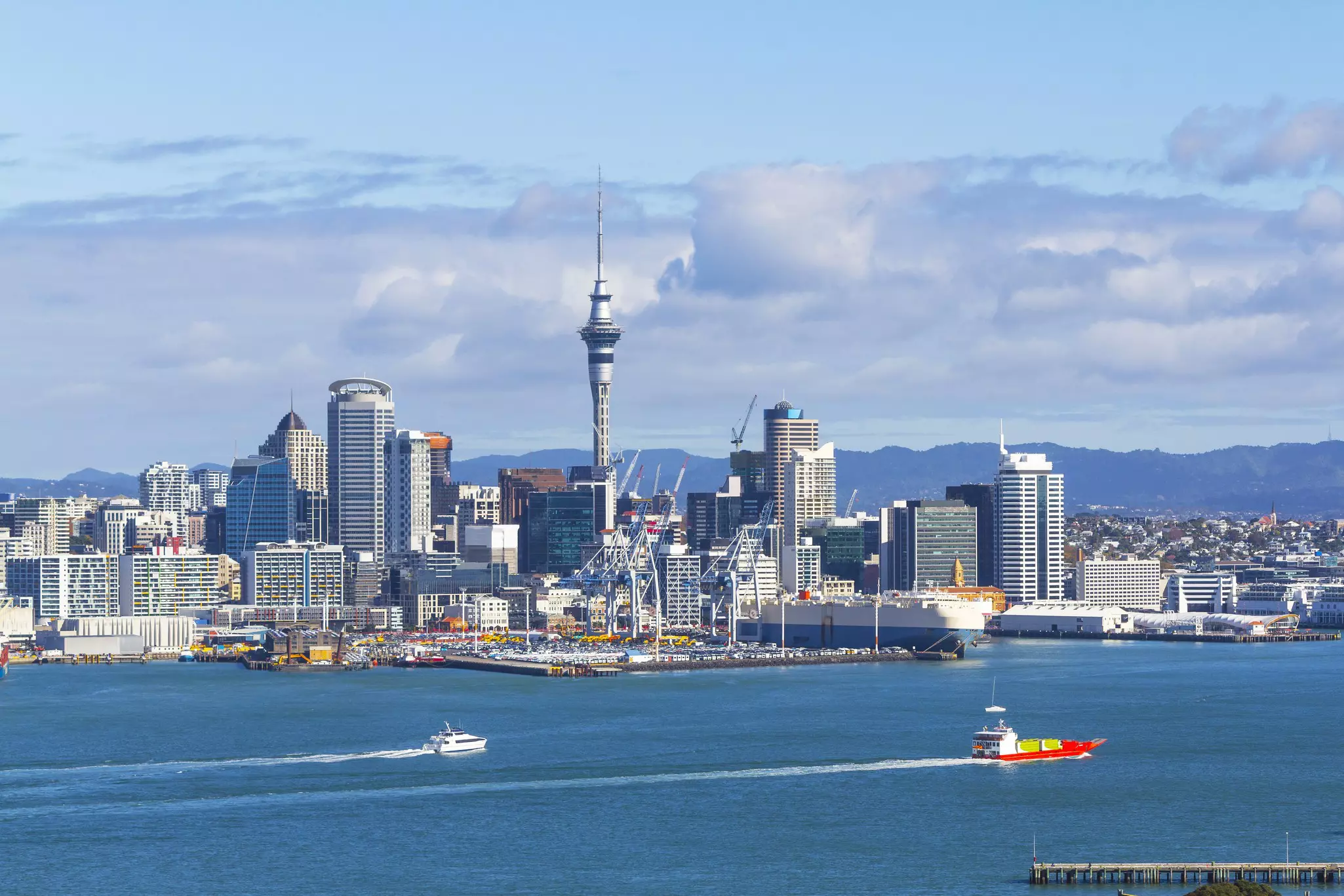 A harbourside city dominated by a large needle-like pointed tower
