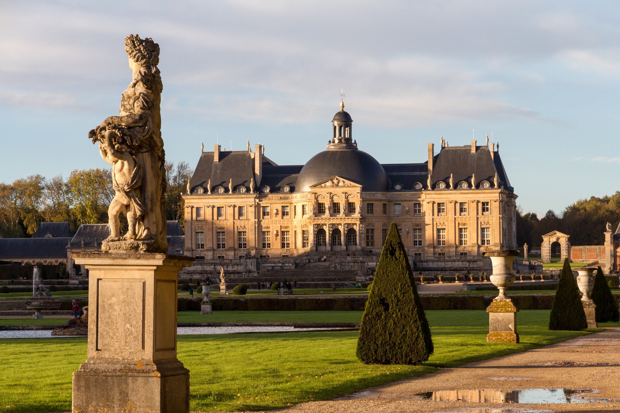 Vaux-le-Vicomte, France - November 1, 2012: Vaux-le-vicomte castle and a statue in the garden during autumn