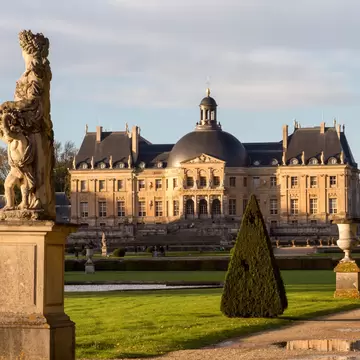 Vaux-le-Vicomte, France - November 1, 2012: Vaux-le-vicomte castle and a statue in the garden during autumn