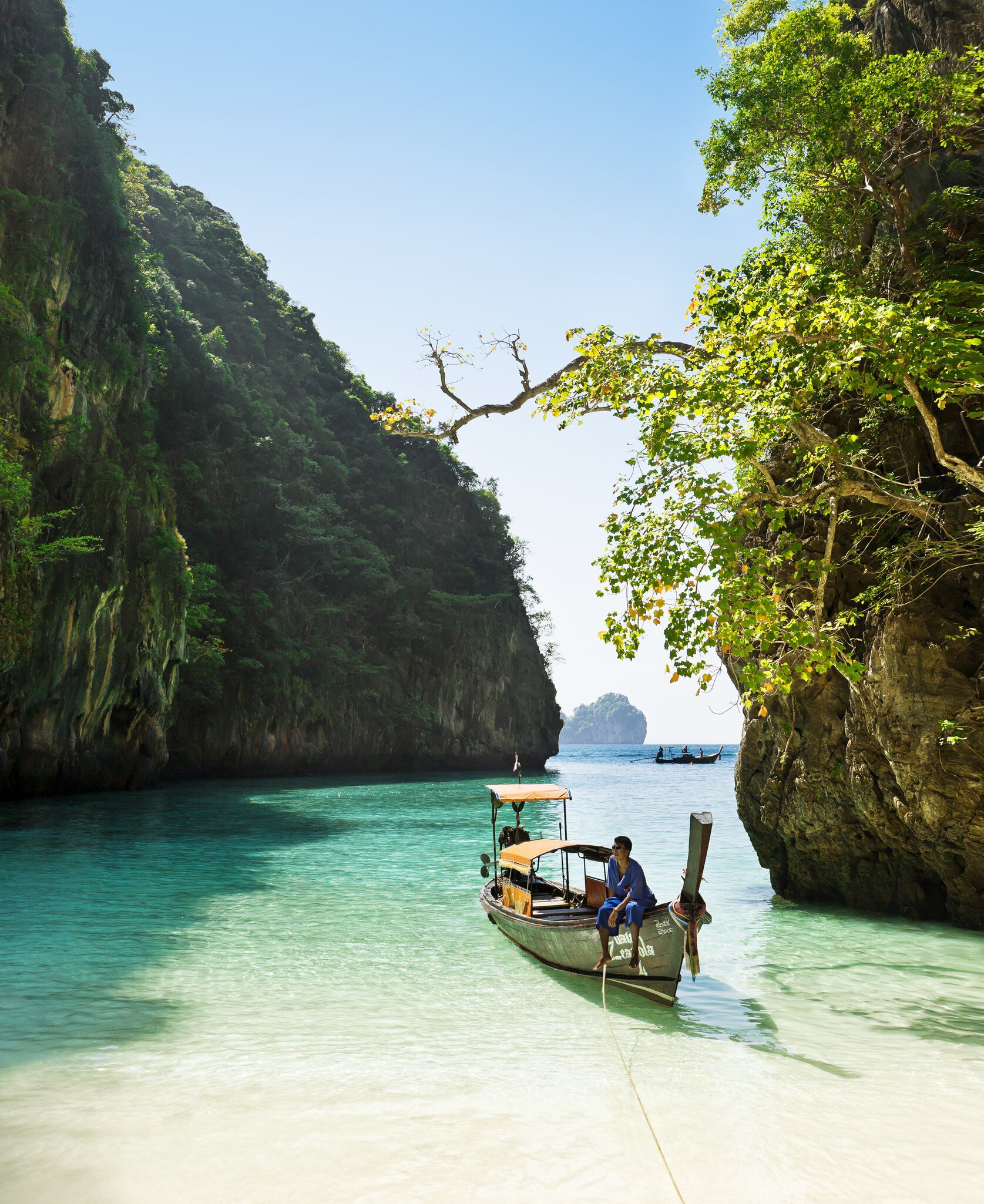 Boatman sitting on longtail boat in Loh Samah bay.
