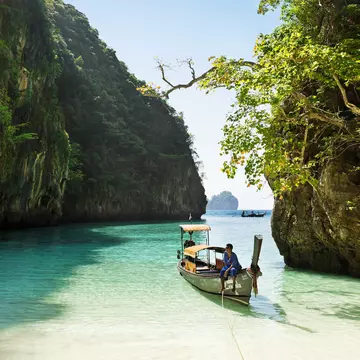 Boatman sitting on longtail boat in Loh Samah bay.