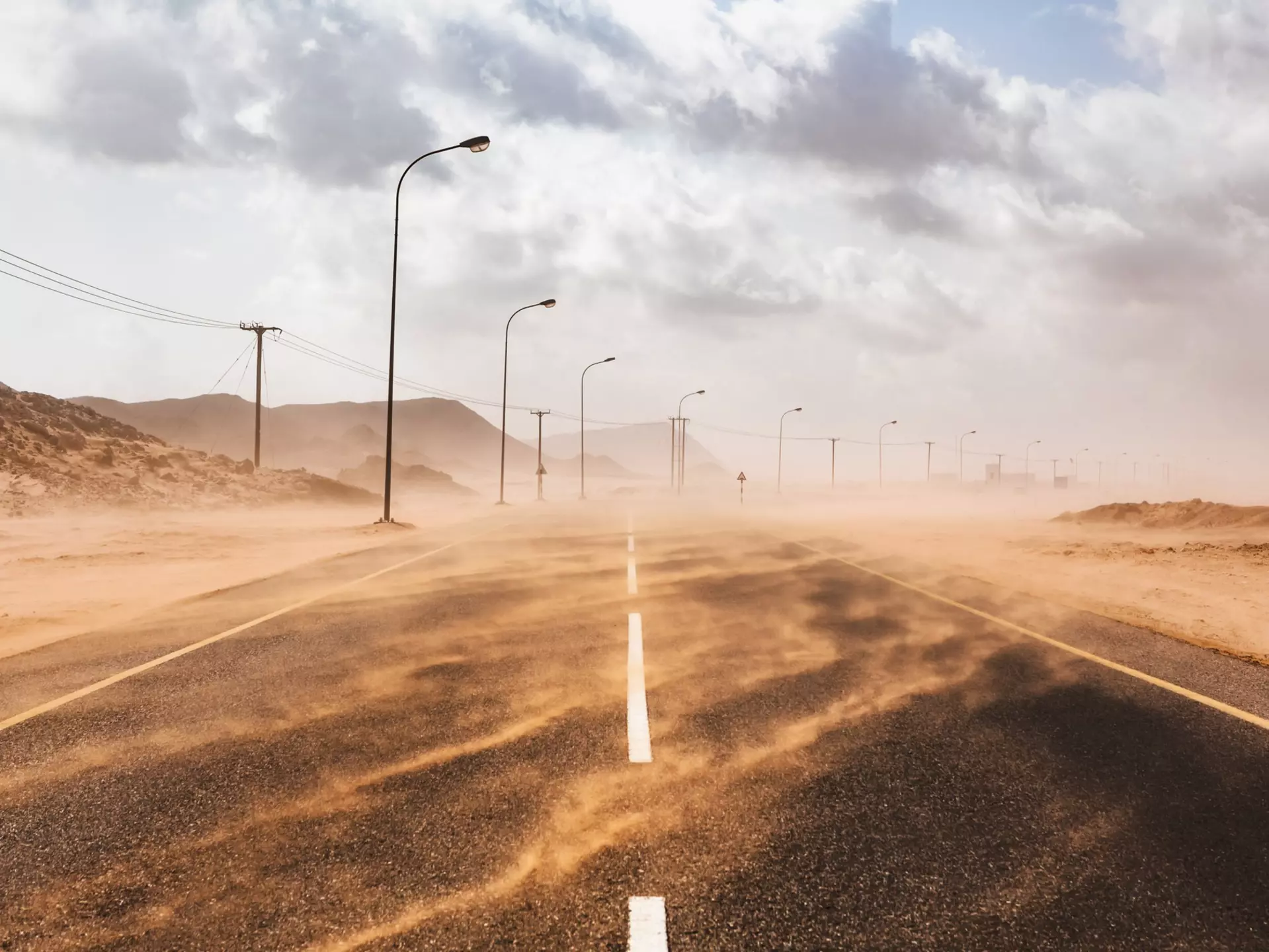 Sand blows across a road during a sandstorm in Ras al Hadd, Oman