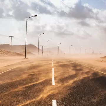 Sand blows across a road during a sandstorm in Ras al Hadd, Oman