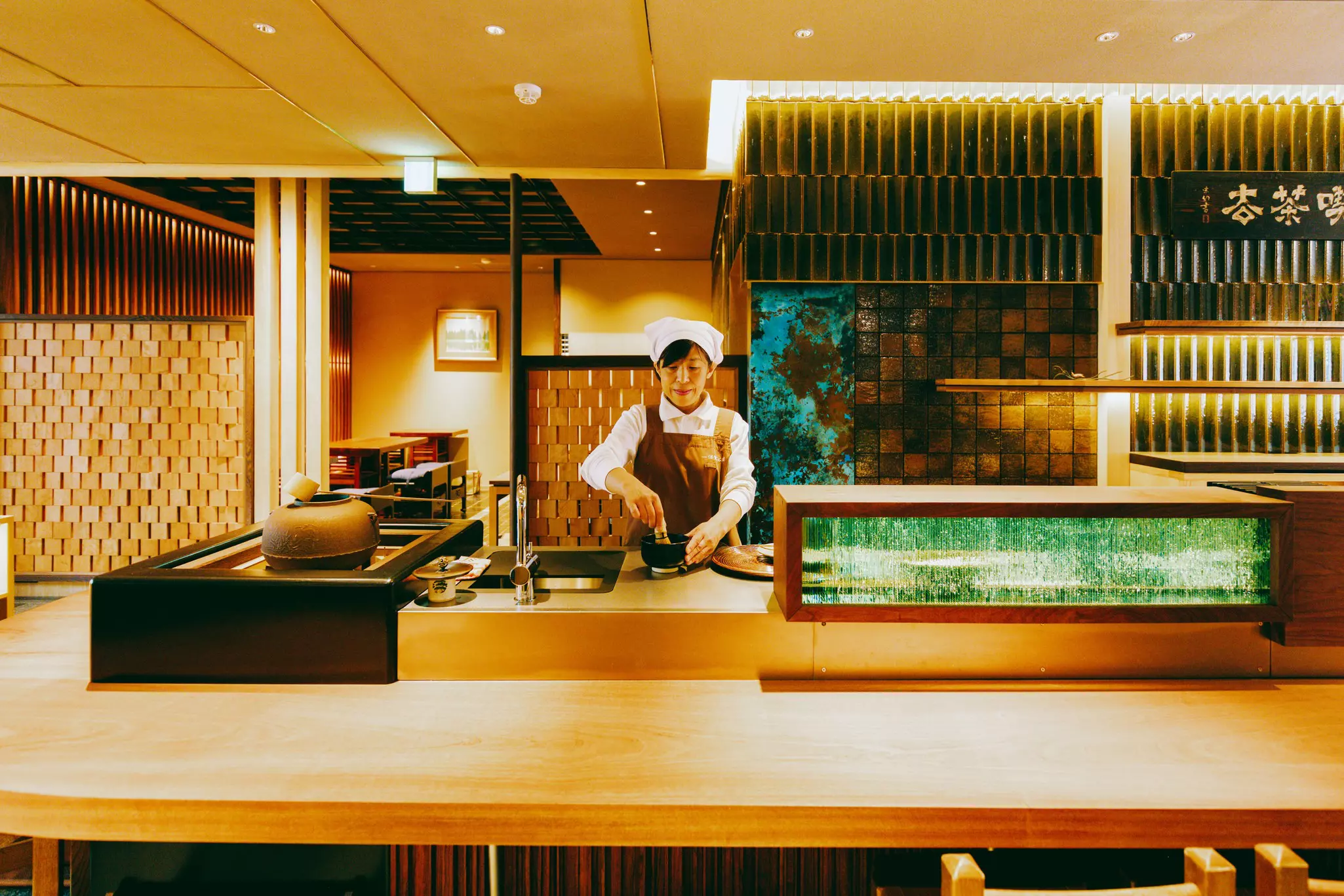 A woman makes matcha in a traditional teahouse.