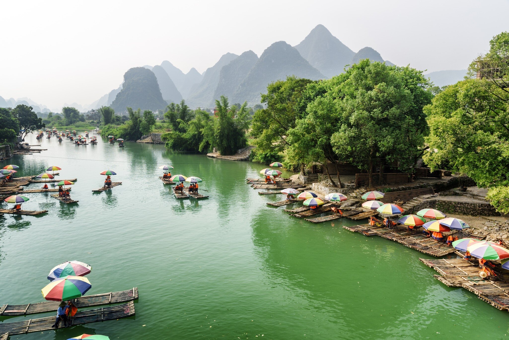 Tourist bamboo rafts on the Yulong River in Yangshuo County. Scenic karst mountains are visible in background.