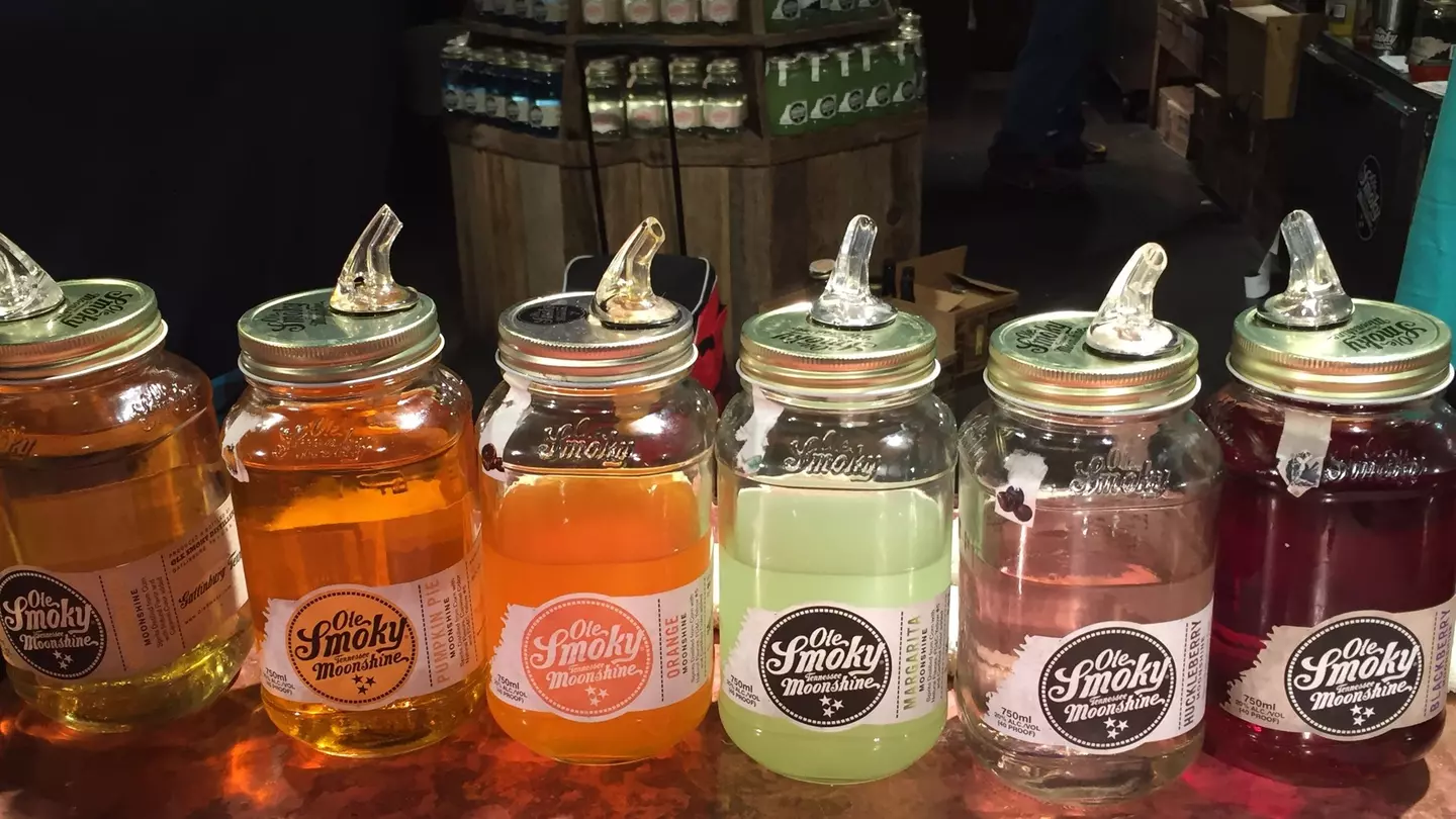 Jars containing colored liquors to taste are displayed on the counter of a distillery.