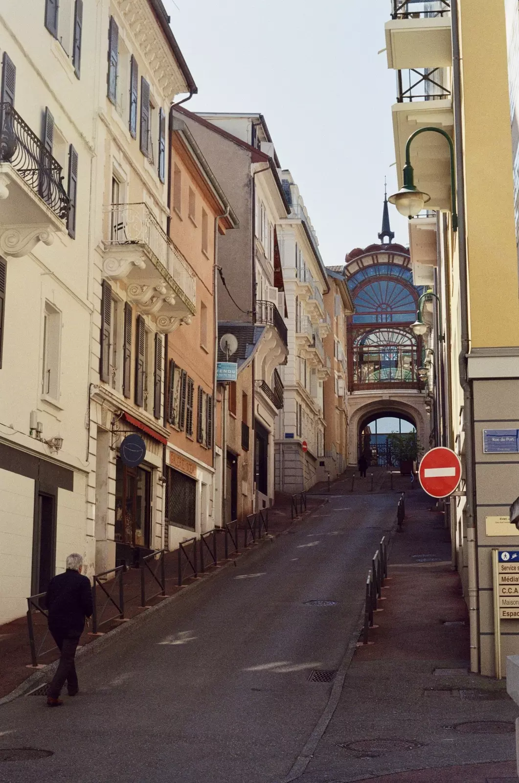 A man walks up an empty street to the Buvette Cachat in Évian-les-Bains, France