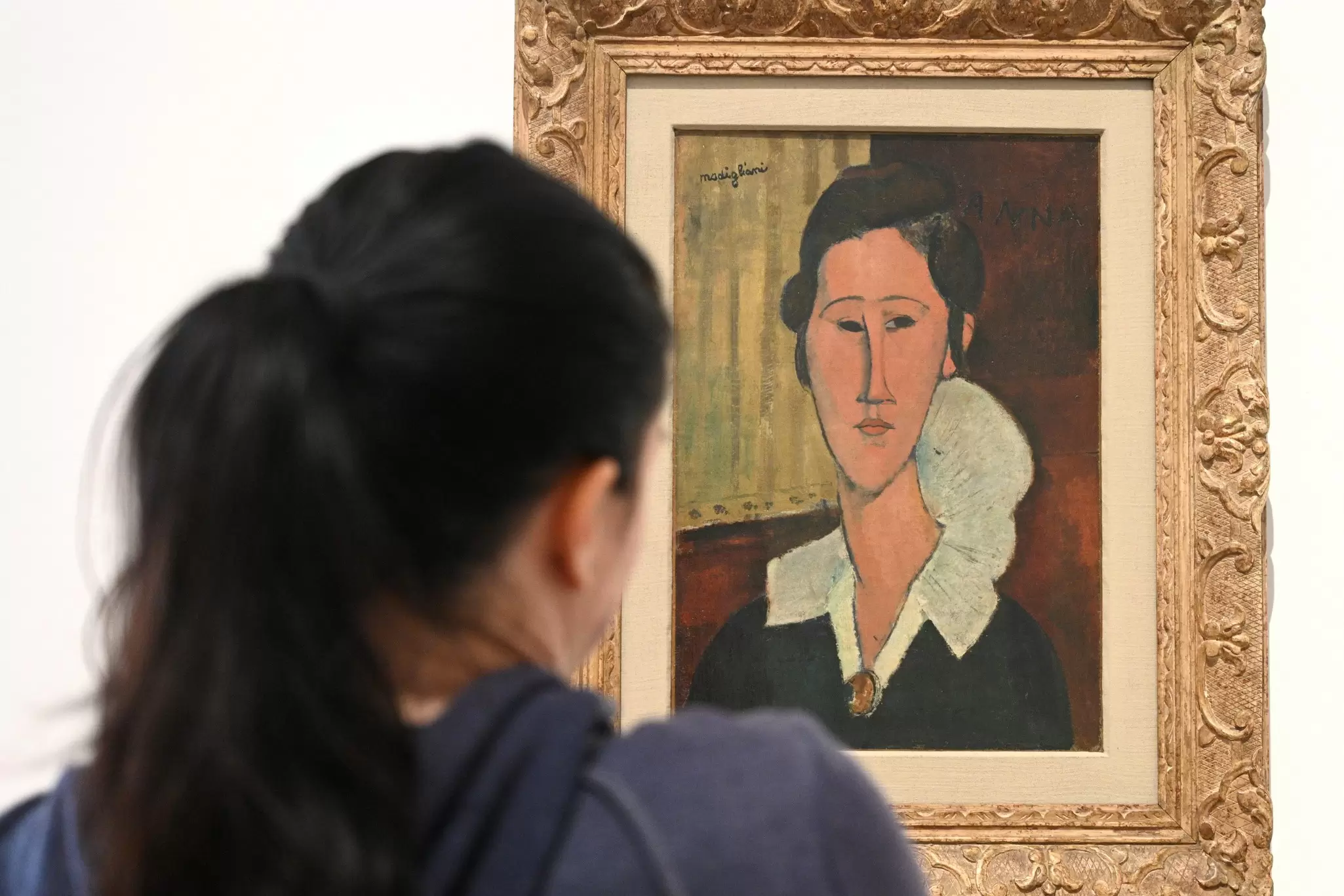 Visitors viewing the 'Portrait of Hanka Zborowska' by Amedeo Modigliani at La Galleria Nazionale in Rome, Italy.