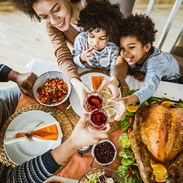 High angle view of happy African American family toasting during Thanksgiving lunch at dining table.
1151543628