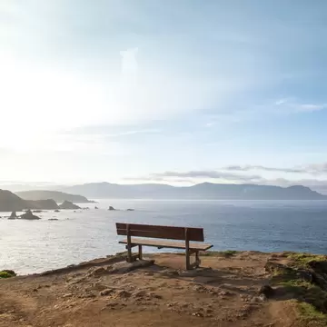 View of a wooden bench, known as the Best Bank of the World (Banco de Loiba), with a stunning view of the sea in Galicia, Spain.