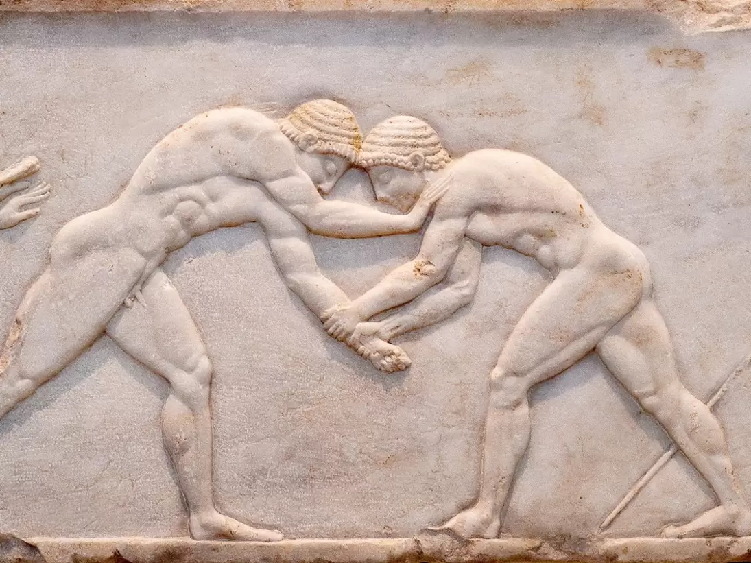 Ancient bas-relief on grave stele in Kerameikos with scene from Palaestra - wrestlers in action. On the left an athlete is ready to jump, on the right another one prepairing the pit. Athens, Greece; Shutterstock ID 1745203673; your: Erin Lenczycki...