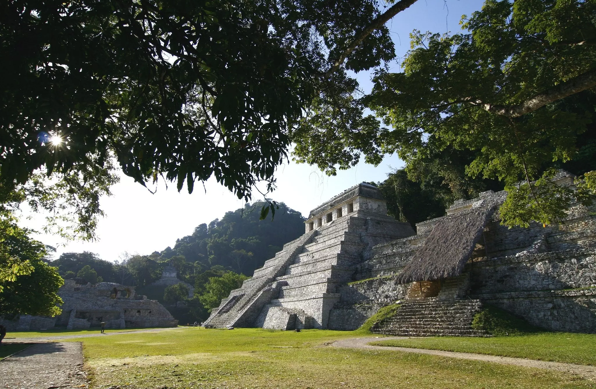 An ancient temple of gray stone in a clearing, with levels stepping up to the top.