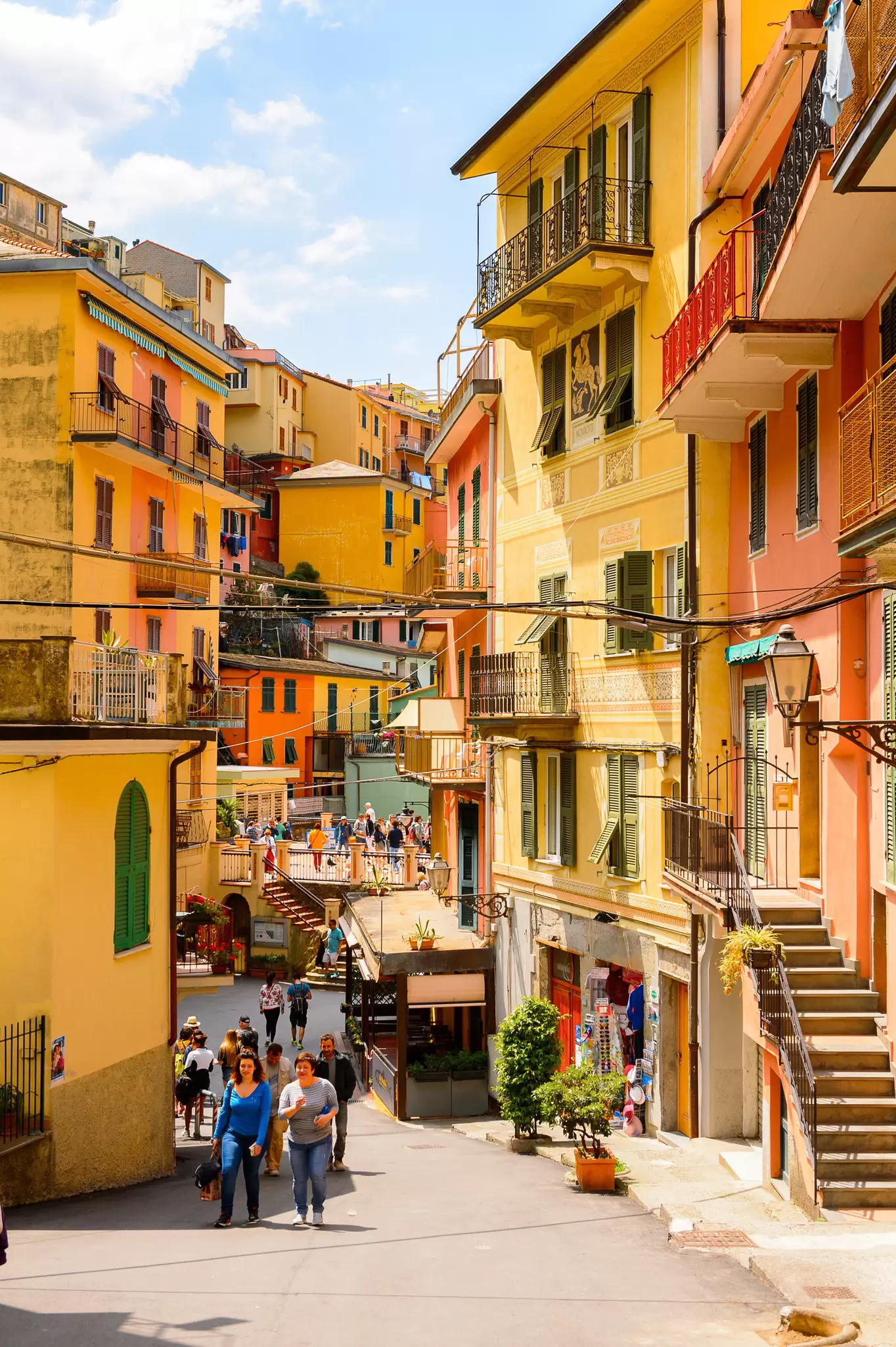 Tourists walking along a village street lined with yellow and orange colored houses