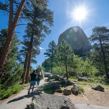 Hikers walk towards Devils Tower National Monument in Wyoming
1813755026
america, attraction, devils tower, devils tower wyoming, erosion, family vacation, formation, geological, geology, indians, lakota, landmark, landscape, monolith, monument, mountain, national monument, national monuments, native american, natural, nature, outdoors, park, pillar, rock, sacred site, scenic, selfies, summer, sunflare, taking photos, tourism, tourists, travel, united states, vacation, volcanic, volcano, western, wilderness, wyoming
