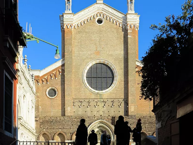 Silhouettes in front of The Basilica dei Santi Giovanni e Paolo, known in Venetian as San Zanipolo, a church in the Catello sestiere of Venice.