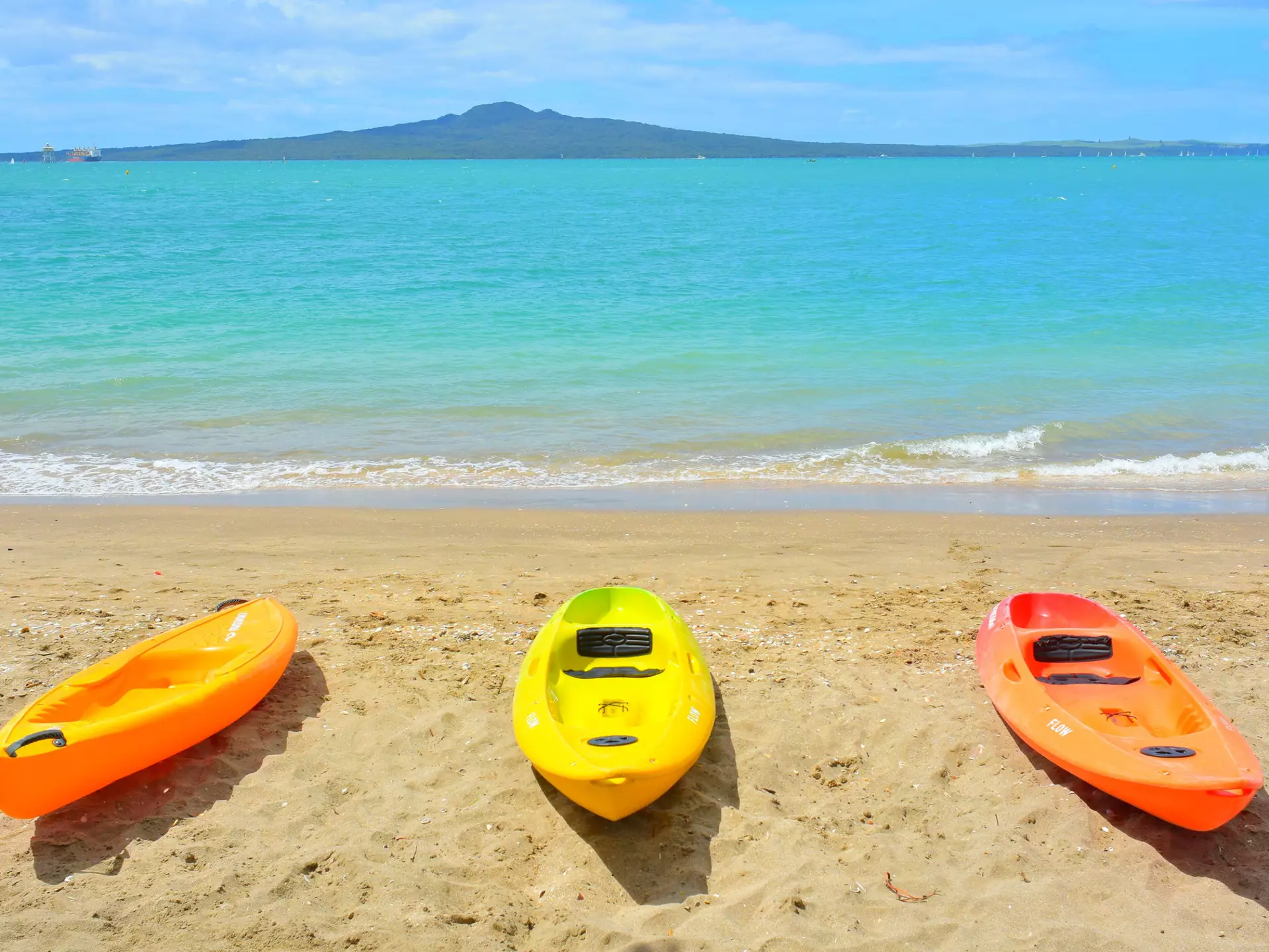 Auckland  New Zealand - November 21 2020: View of three colourful kayaks at Mission Bay with Rangitoto Island in background  License Type: media  Download Time: 2022-04-28T10:23:46.000Z  User: aniabartoszek  Is Editorial: Yes  purchase_order: