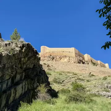 View of Albarracín Citadel framed by tall grass in the foreground in Aragon, Spain.