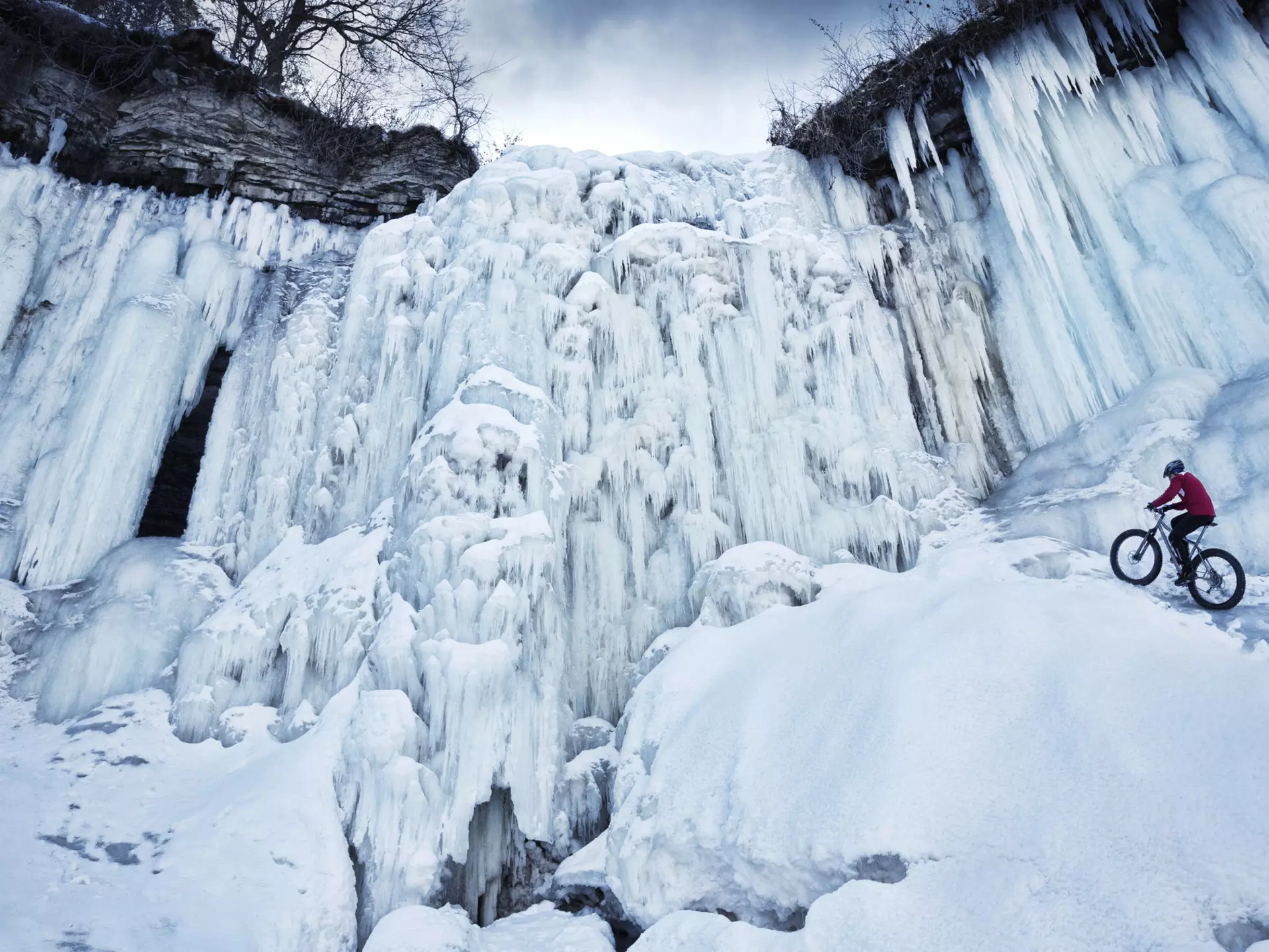 A bike rider climbing up the frozen Minnehaha waterfall in Minneapolis