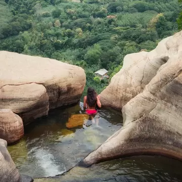 A woman sitting in the pools at the Diyaluma Waterfall in Southern Sri Lanka.