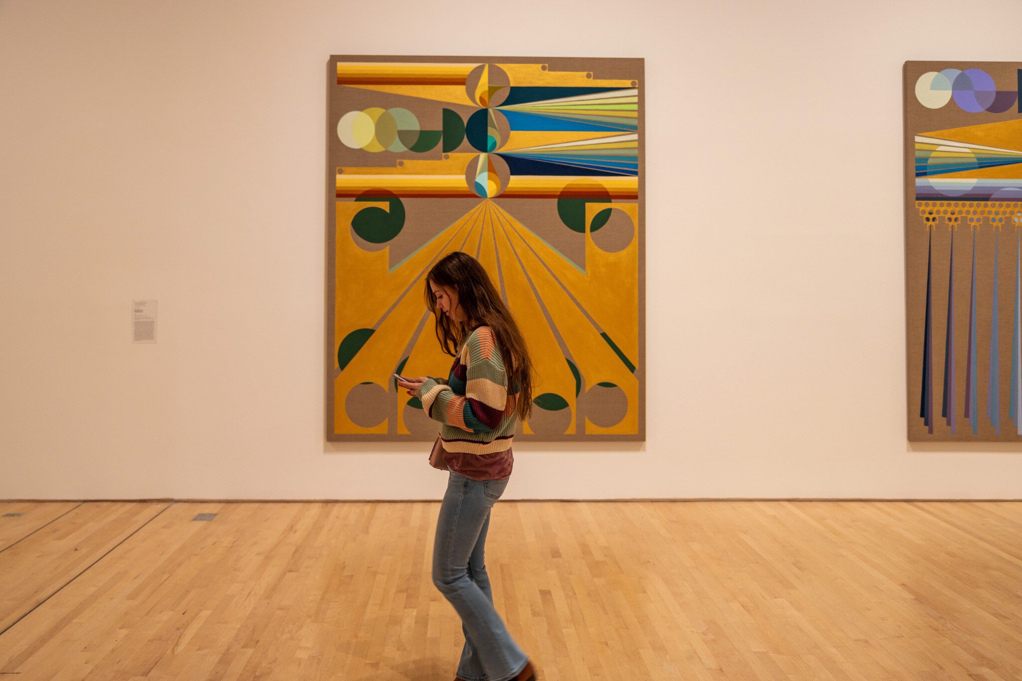 A visitor walking past a painting at a modern art museum in San Francisco