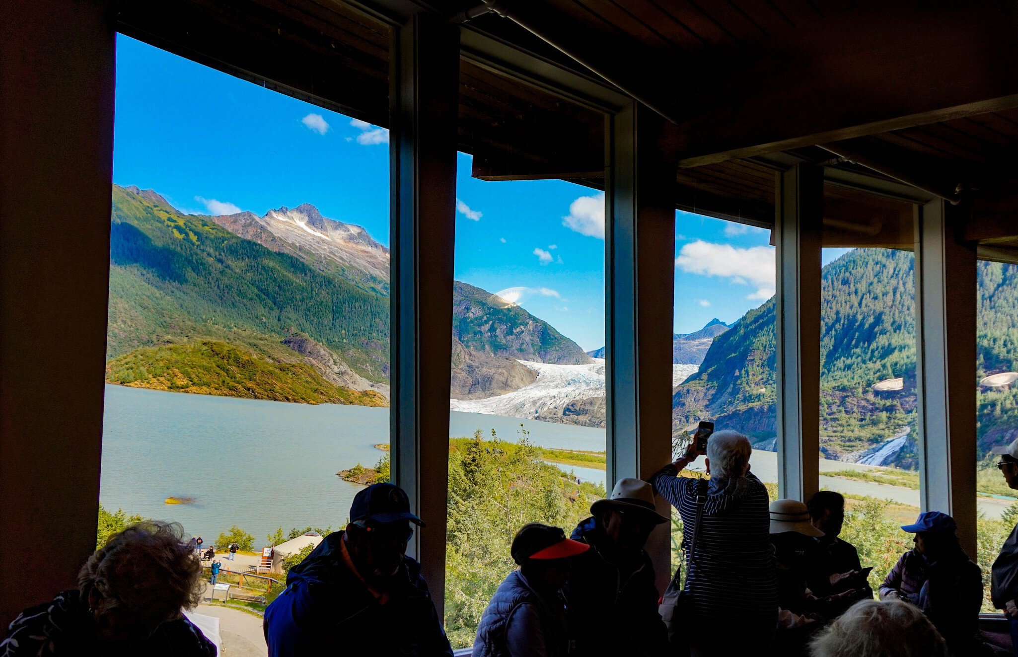 Mendenhall Glacier, Juneau, Alaska, USA- From the inside of visitor center, people looking through the window to see the glacier