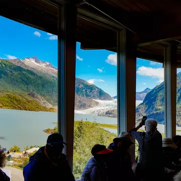 Mendenhall Glacier, Juneau, Alaska, USA- From the inside of visitor center, people looking through the window to see the glacier