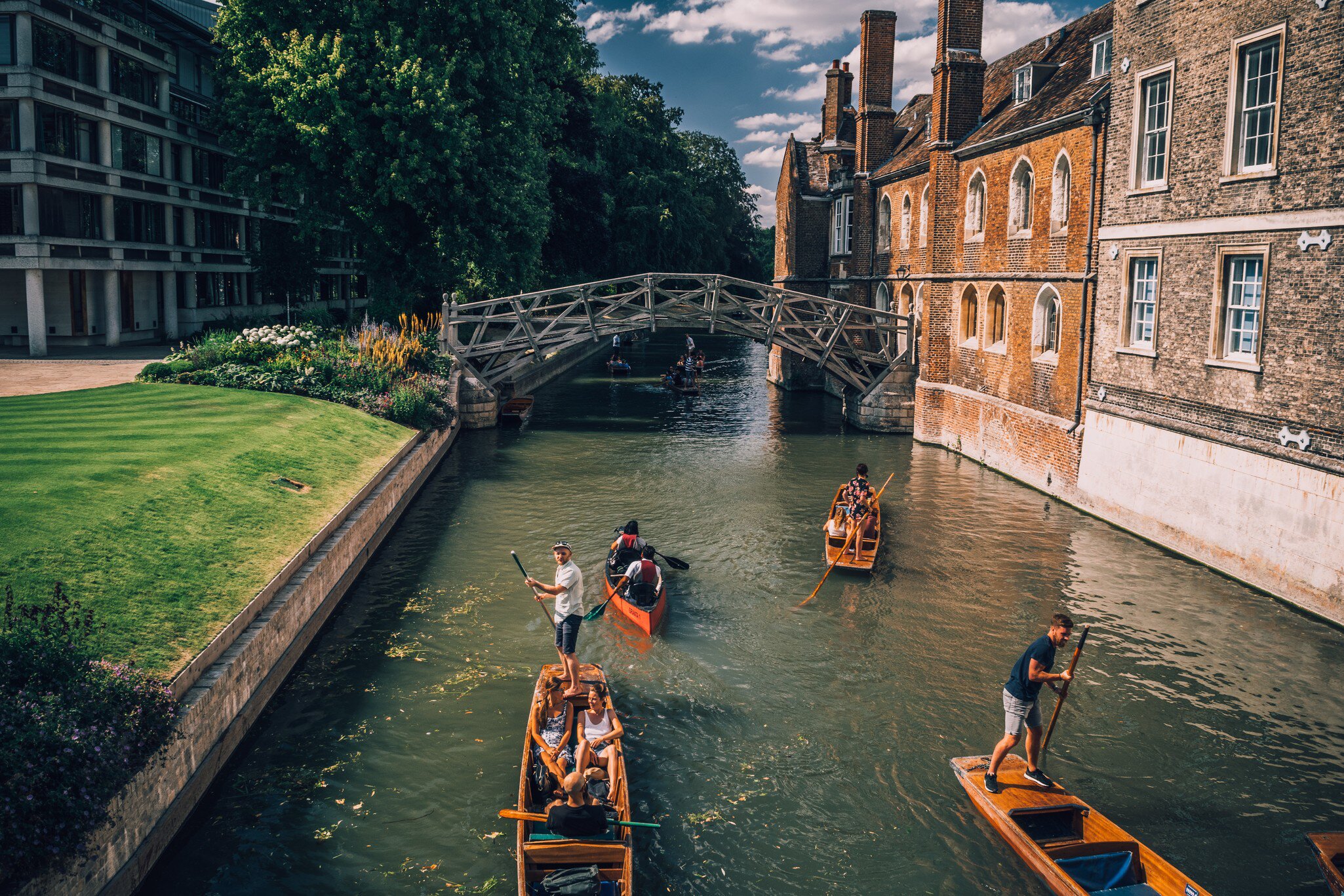 Cambridge, UK - August 20, 2017 : People punting in a canal next to the Mathematical bridge  License Type: media  Download Time: 2022-05-26T15:42:56.000Z  User: clairenaylor  Is Editorial: Yes  purchase_order:   