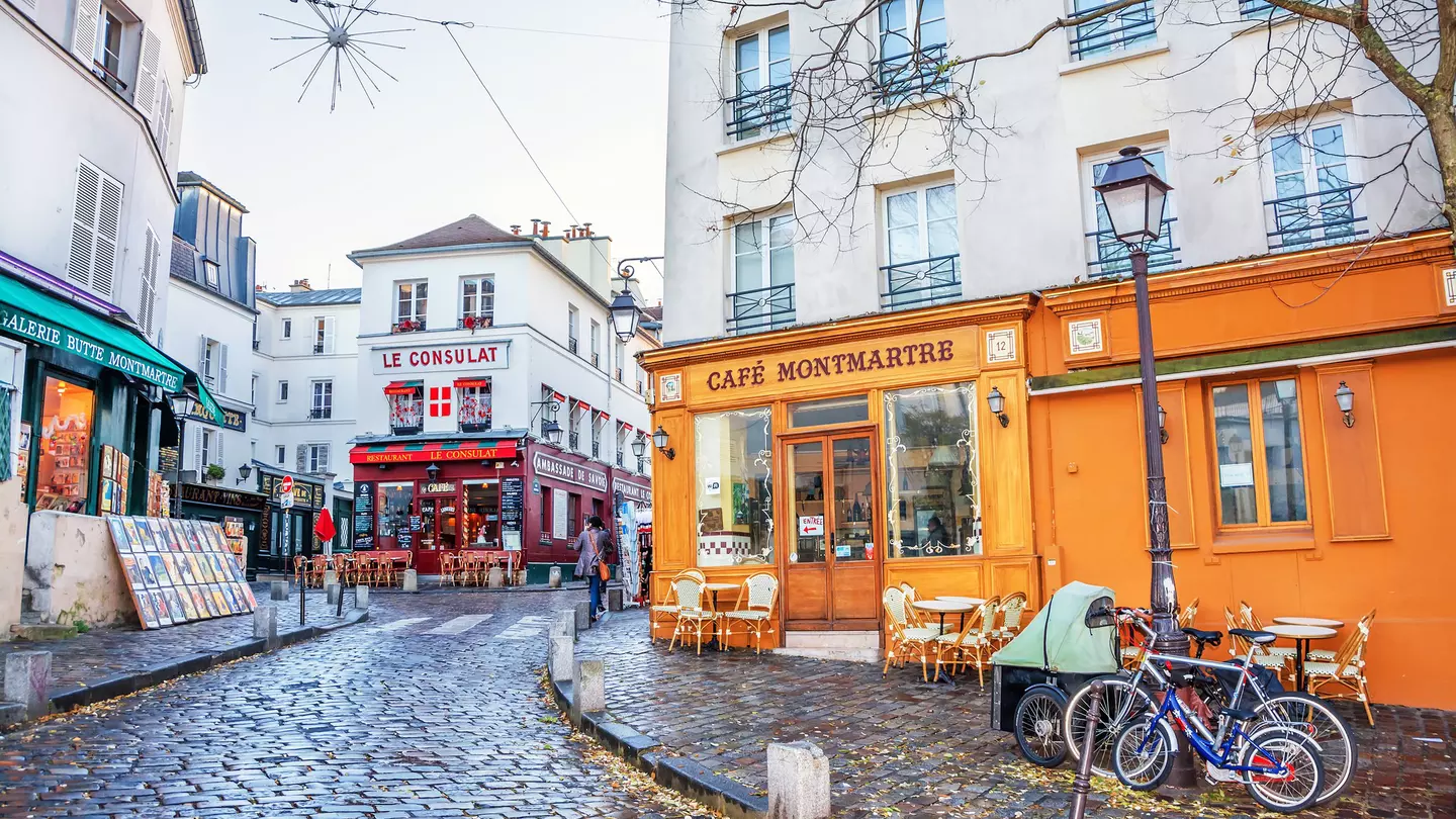 A French street in the Montmartre district with small cafes, restaurants and art galleries.