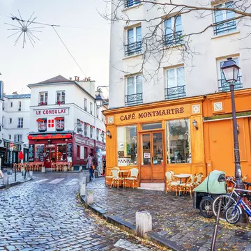 A French street in the Montmartre district with small cafes, restaurants and art galleries.