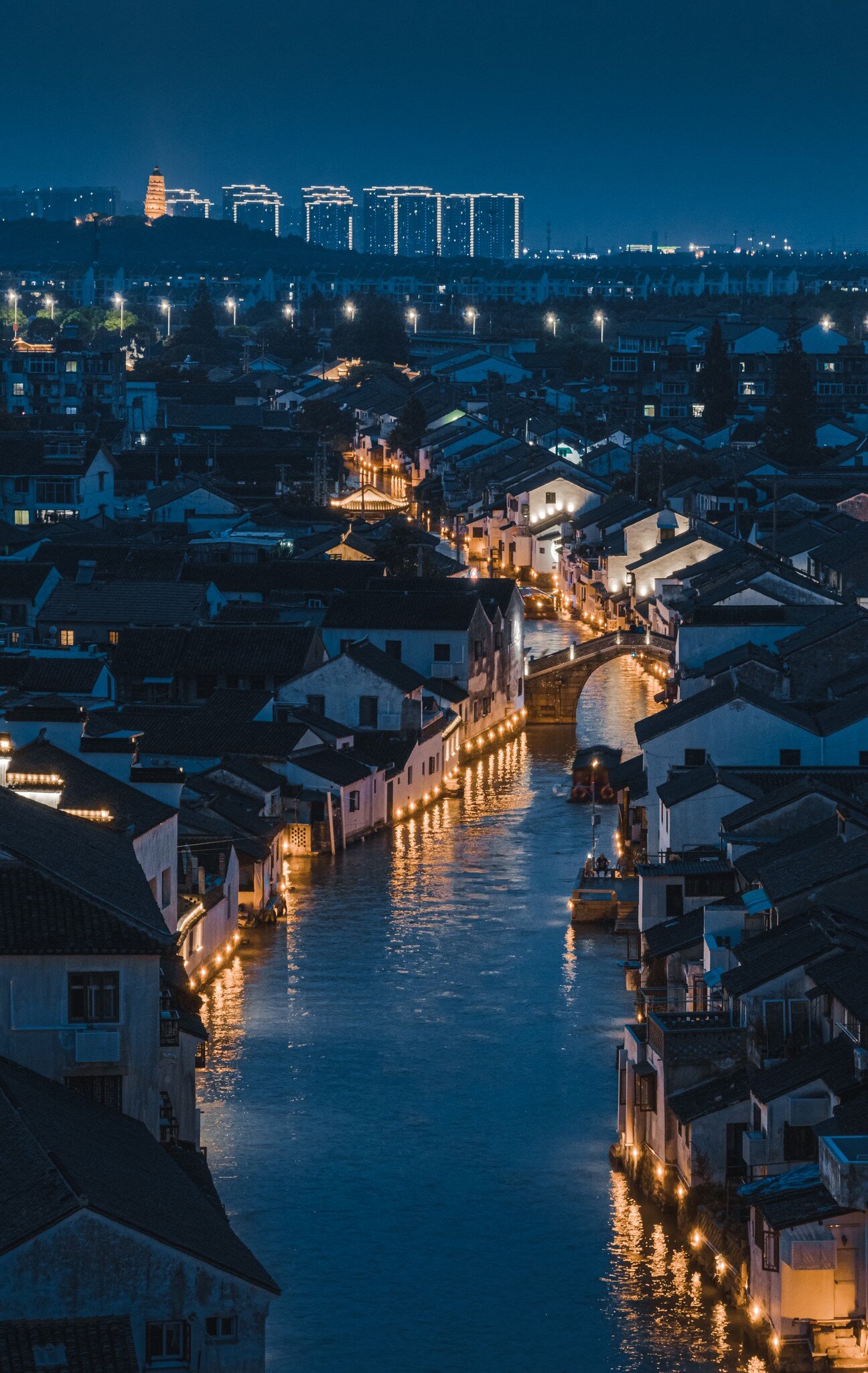 Shantang river at night and Shantang Street in Suzhou with street lamps lining it glowing a warm hue