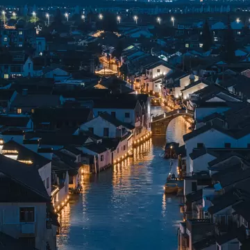 Shantang river at night and Shantang Street in Suzhou with street lamps lining it glowing a warm hue