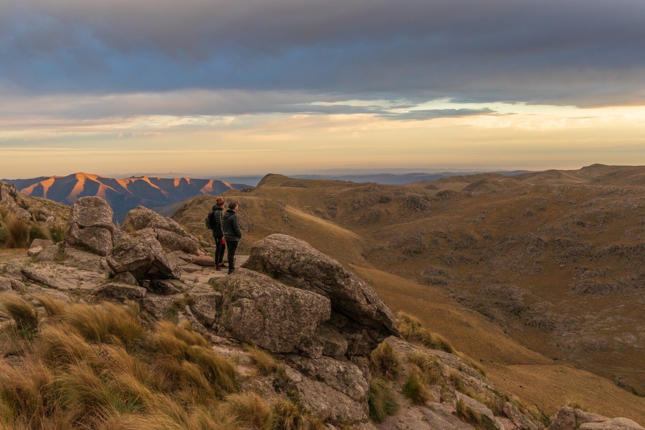 Two people standing on Cerro Uritorco, a mountain and highest peak of the Sierras Chicas chain in the northwest of the province of Cardoba, Argentina.  