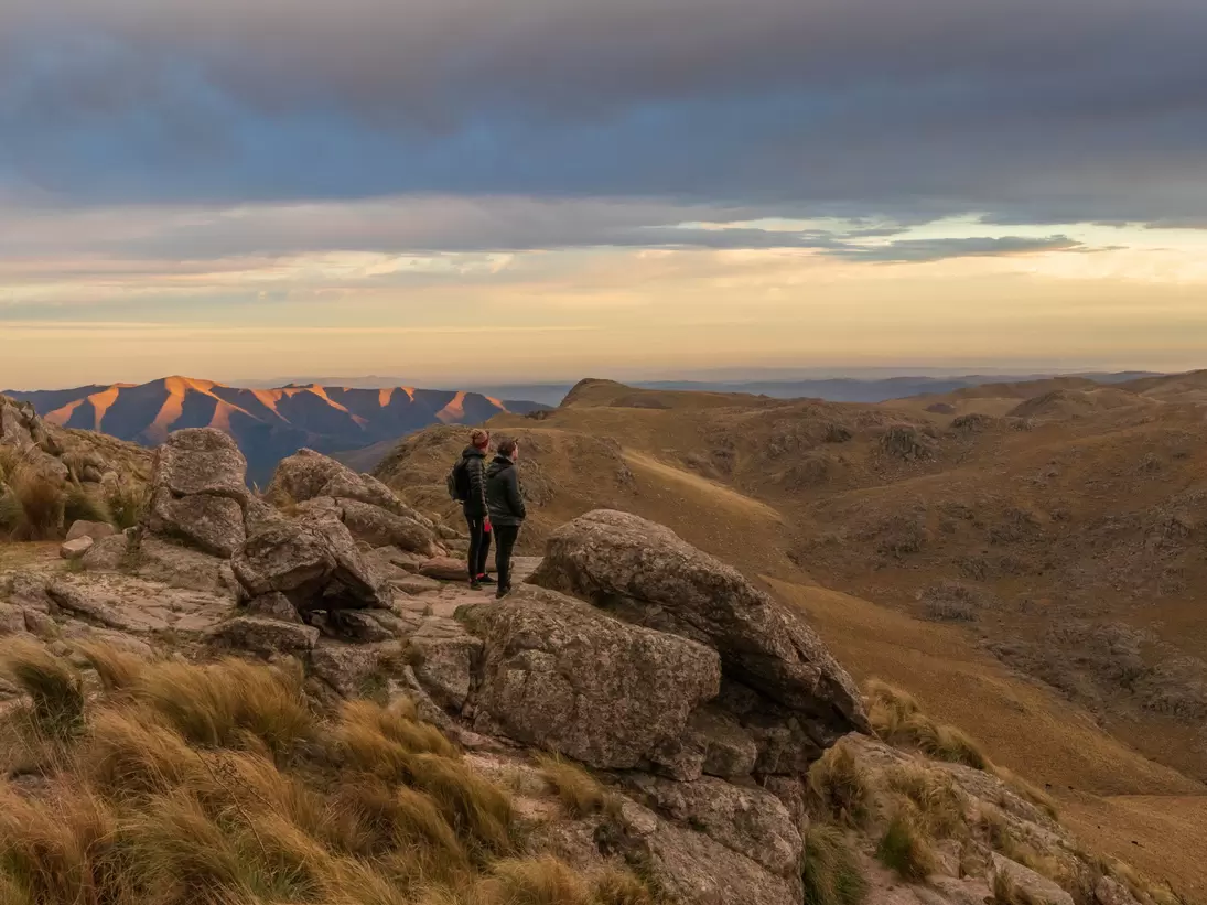Two people standing on Cerro Uritorco, a mountain and highest peak of the Sierras Chicas chain in the northwest of the province of Cardoba, Argentina.  