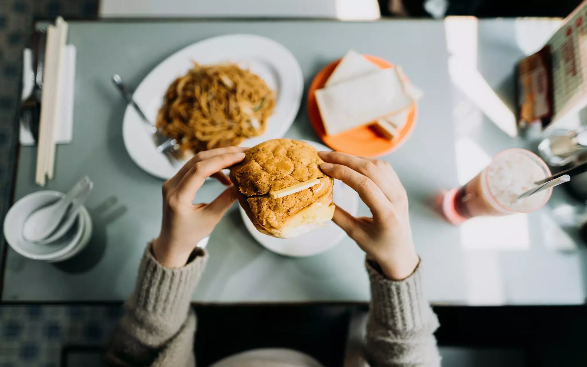 A diner eating a pineapple bun (bo lo bao) in Hong Kong.
