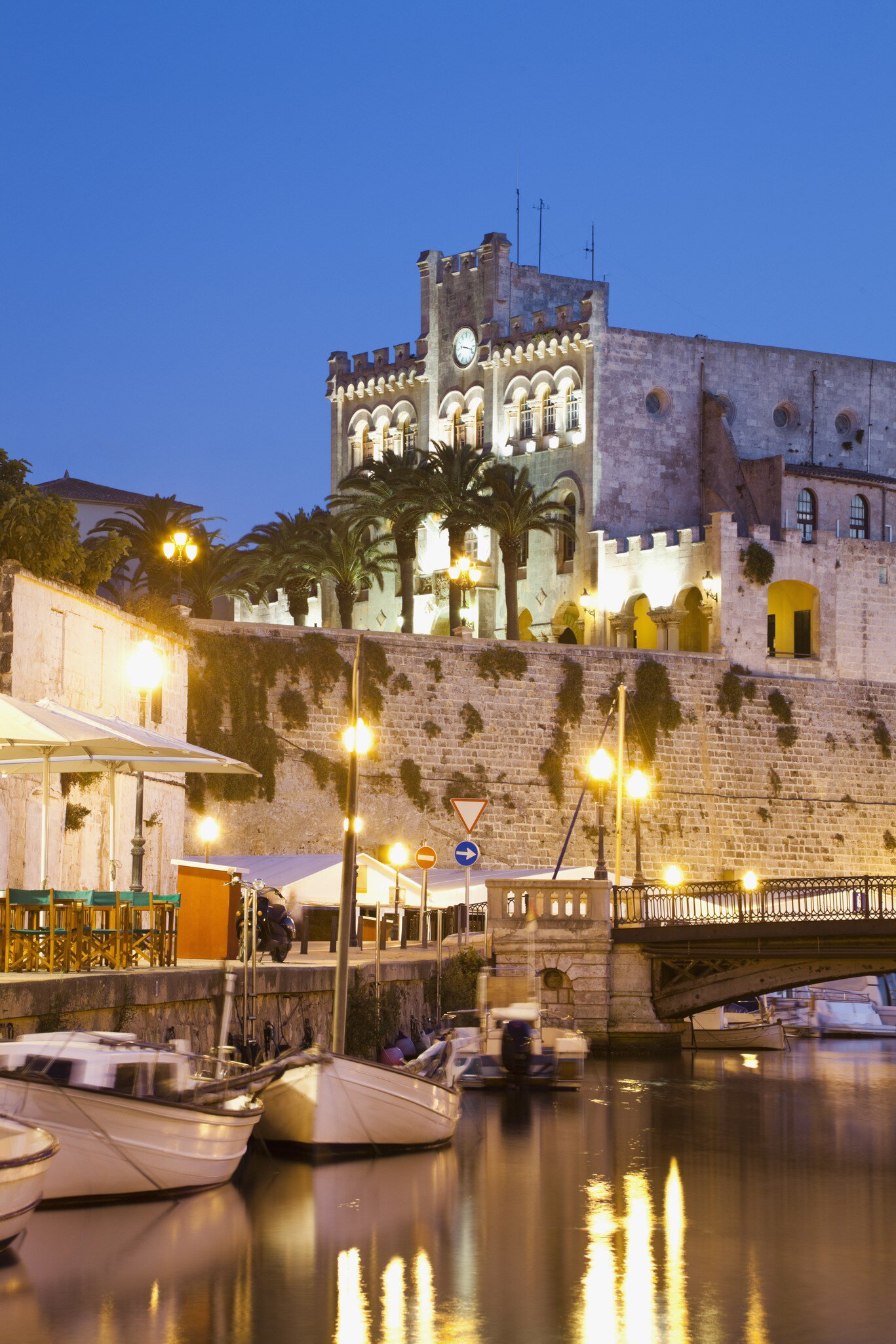 Nighttime view across the water of the Museu Municipal in the Ciutadella of Menorca, Spain.