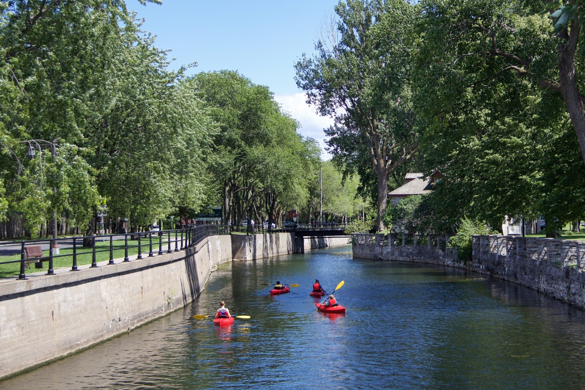 Lachine, Montrel, Canada. July 2021. Man kayaking in the Lachine canal water scenic view of environmental friendly suburbia rich in green trees