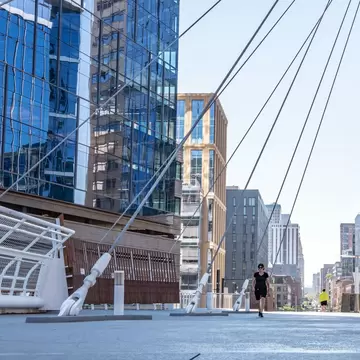 Denver, Colorado - August 28, 2021: People cross the Millennium Bridge on 16th street downtown, in the LoDo (Lower Downtown) neighborhood.