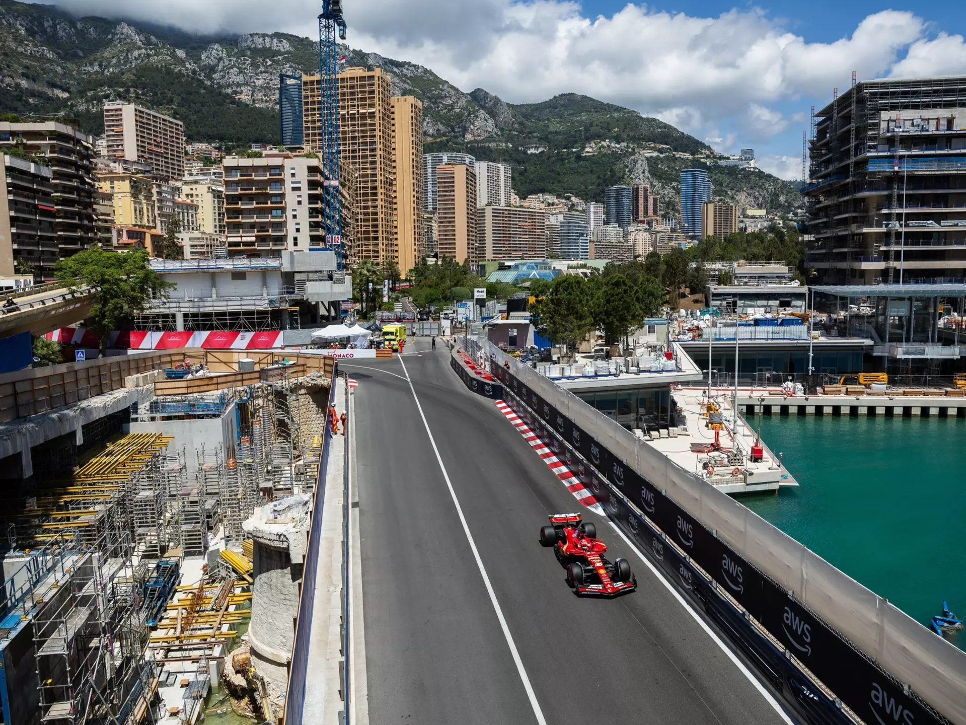 An overhead view of a red race car on a city street by the harbor