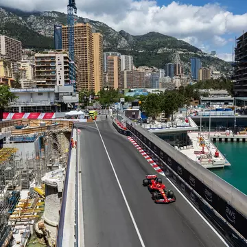 An overhead view of a red race car on a city street by the harbor