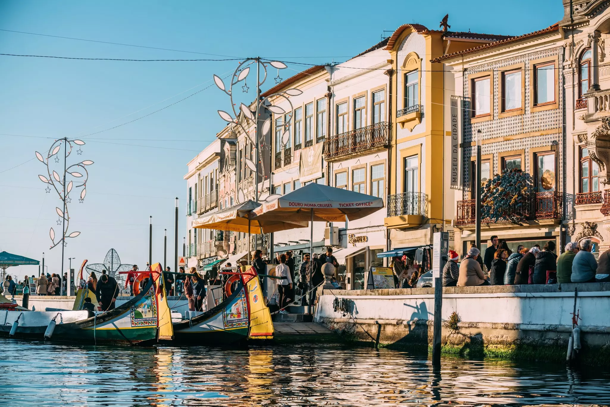Colorful traditional boat docked in Aveiro, Portugal with vibrant architecture in the background.